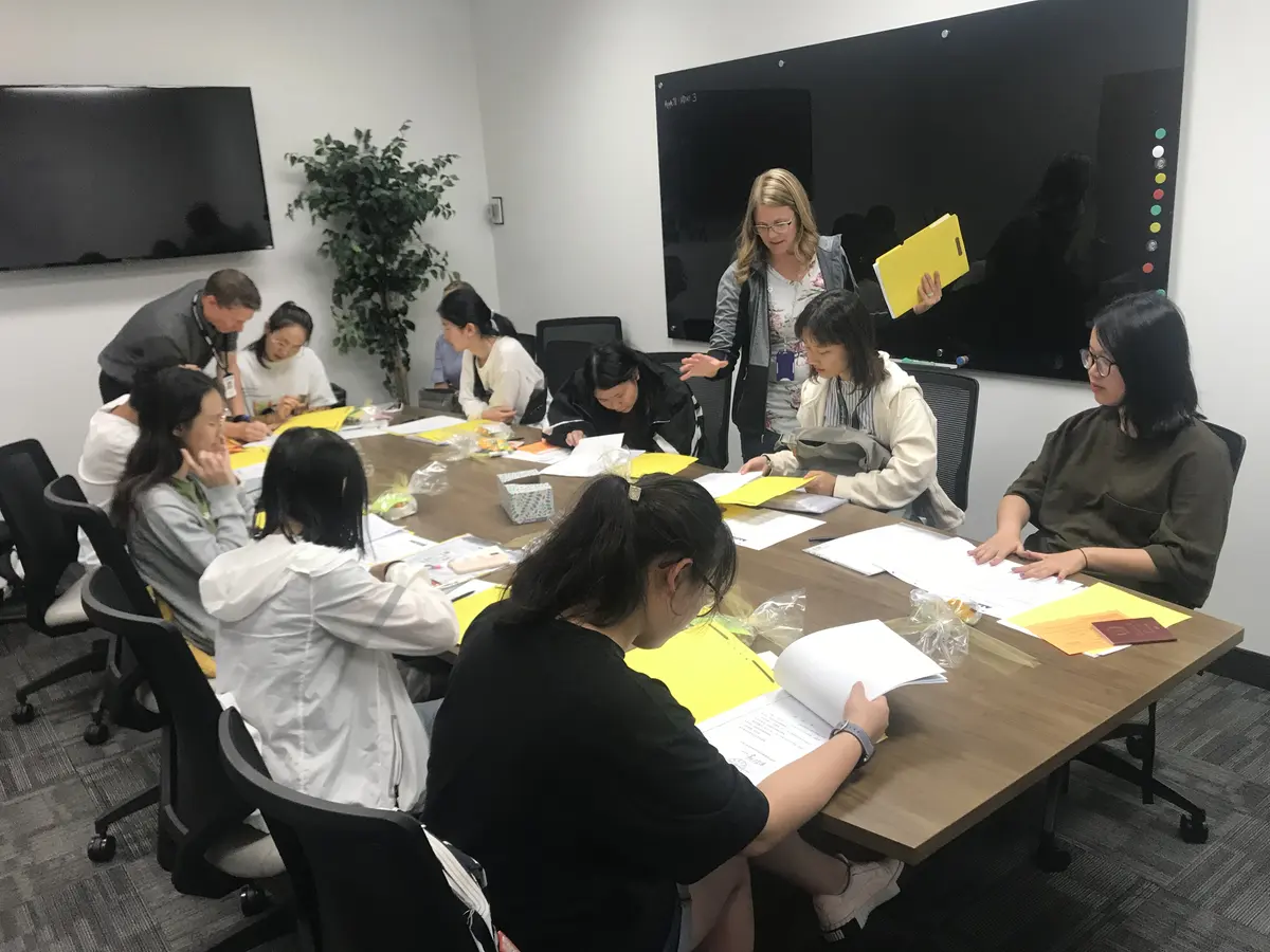 中美教师带领学生围桌完成课程材料与小组任务